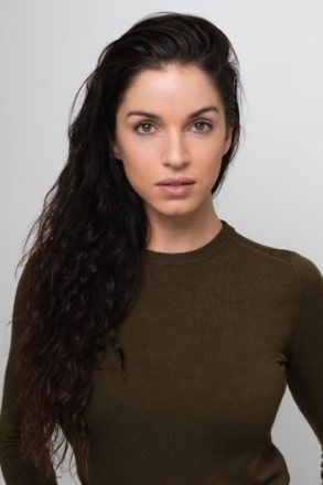 Tara Wraith posing for a photoshoot by wearing brown sweater.